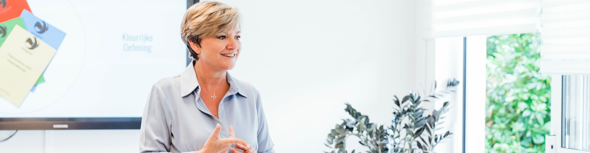 Een vrouw geeft les over een teamgerichte training rond Insights Discovery