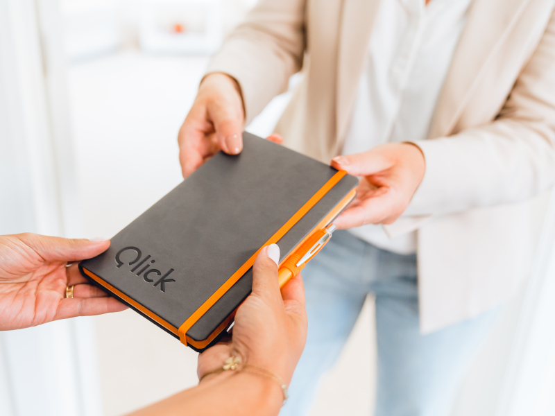Een coach overhandigt een Qlick Boekje aan een coachee voor opstart van een coaching traject