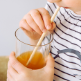 Child enjoys a drink with pasta straw