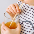 Child enjoys a drink with pasta straw