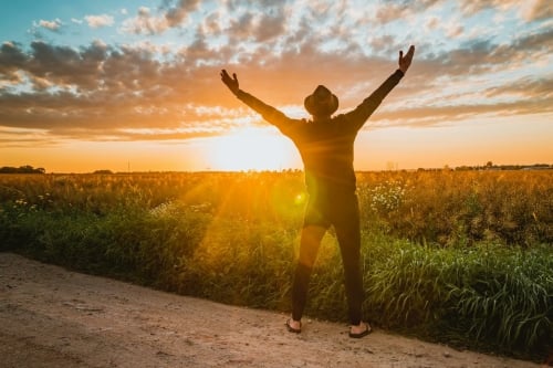 Man staat op een open veld na terugpakken van de regie na regressie sessie bij Regressiepraktijk in den haag of duin, vroeg in de ochtend