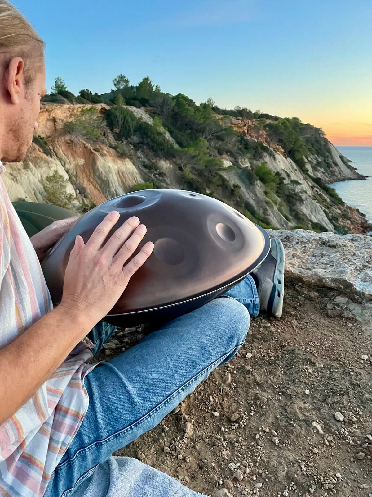 Erno Van Doesselaar playing handpan at sunset