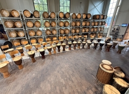 Workshop djembé Ritmus Opstelling voor een djembé workshop en muzikale teambuilding met tientallen djembés en stoelen.