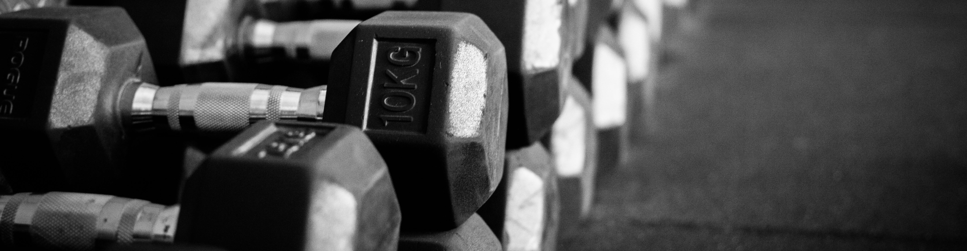 Een zwart wit foto met daarop een set dumbbells