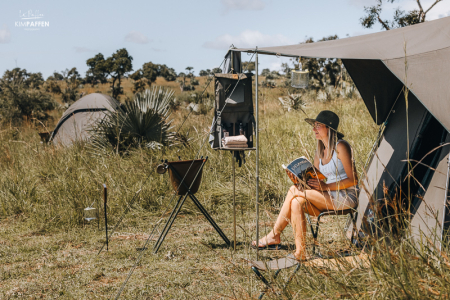 Tessa leest boek voor haar tent tijdens meerdaagse wandel en kampeer safari in Murchison Falls National Park Oeganda