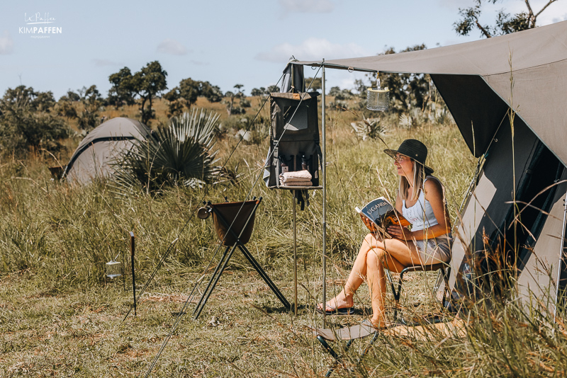 Tessa leest boek voor haar tent tijdens meerdaagse wandel en kampeer safari in Murchison Falls National Park Oeganda
