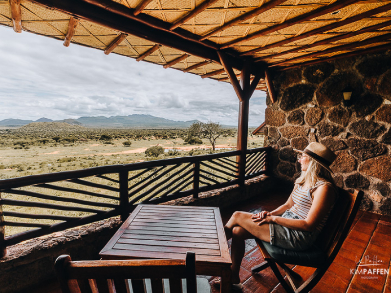 Luxe suite met uitzicht bij Kilaguni Serena Safari Lodge in Kenia Vrouw op het privéterras van de luxe suite van Kilaguni Serena Safari Lodge met uitzicht op de Chyulu Hills en de Kilimanjaro