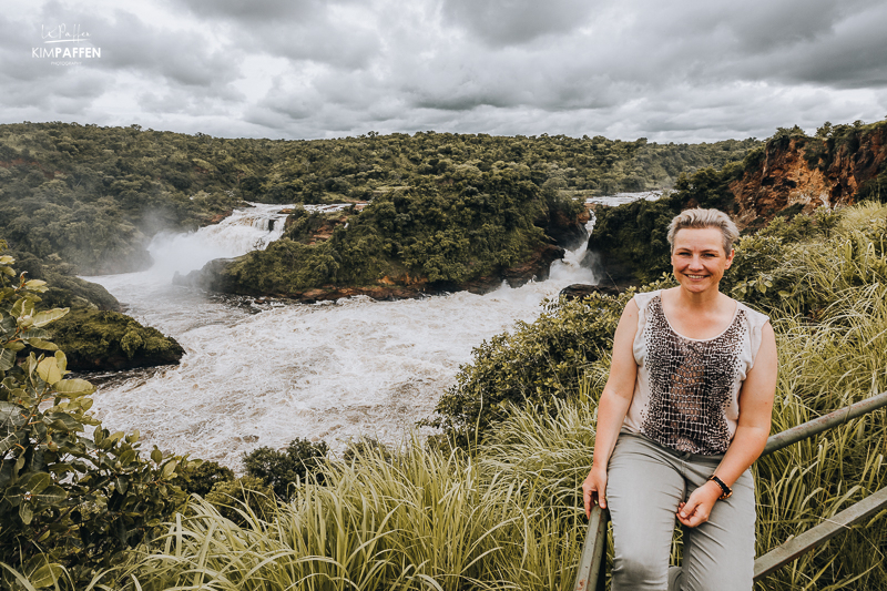 Kim Paffen poseert met Murchison Falls op de achtergrond tijdens de Top of the Falls Hike in Murchison Falls National Park