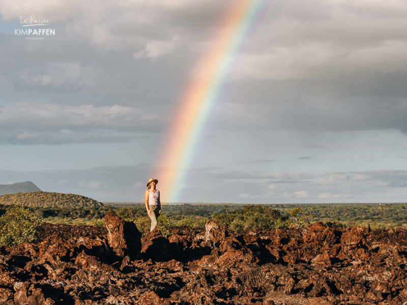 Uitgestrekt zwart lavaveld van Shetani Lava Flow in Tsavo West National Park met een safari-voertuig op de achtergrond