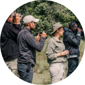 Groep reizigers gebruikt verrekijkers om vogels te spotten tijdens een wandel safari door de Afrikaanse savanne
