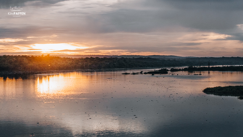 Zonsopkomst over de rivier de Nijl bij Murchison Falls, met gouden tinten weerspiegeld in het water.