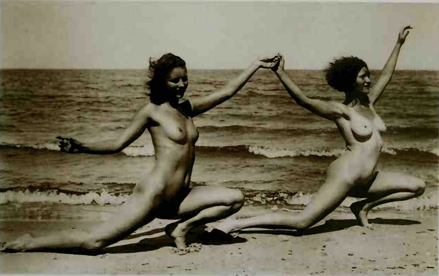 2 nude females holding hands on the beach
