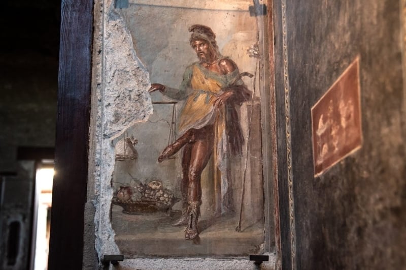 A fresco depicting God Priapus in the House of the Vettii in the Archaeological Park of Pompeii