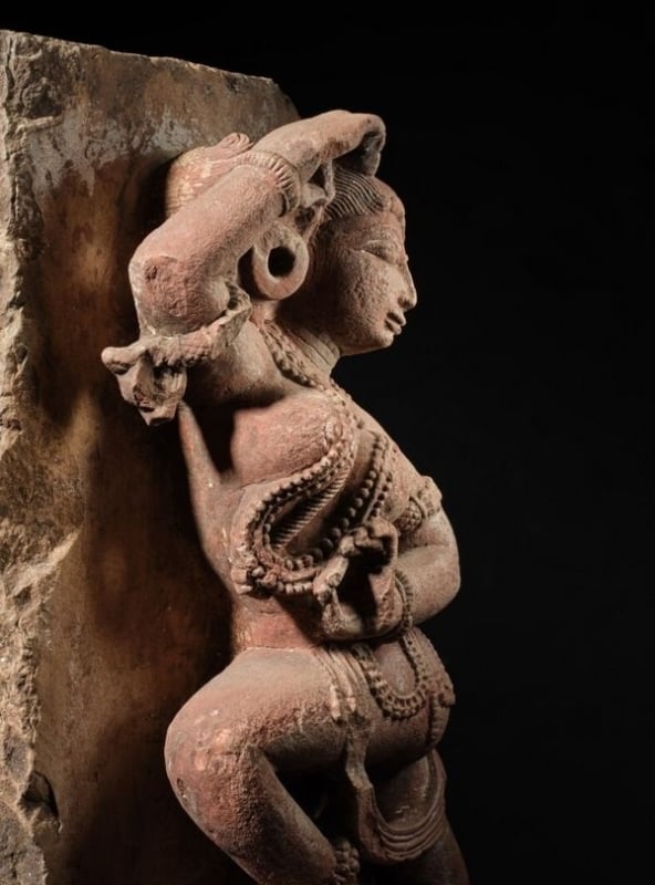 A mottled red sandstone figure of a dancing Yakshi, Rajasthan, circa 11th century