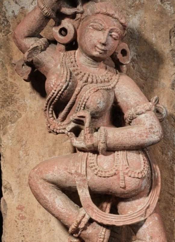 A mottled red sandstone figure of a dancing Yakshi, Rajasthan, circa 11th century