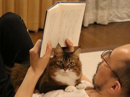 Toshiyuki Enoki reading with his cat