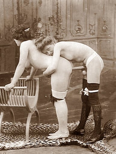 vintage photo Two females experimenting with a strap-on standing on a leopard skin