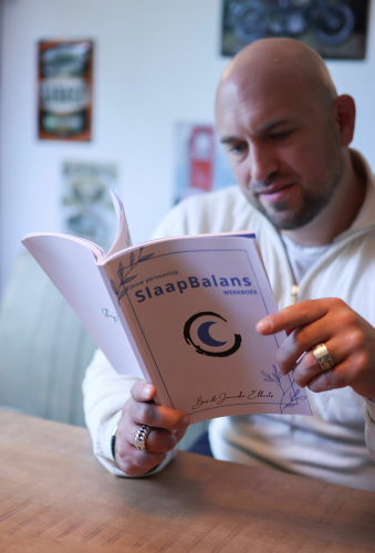 Slaapcoach Bas bekijkt het werkboek