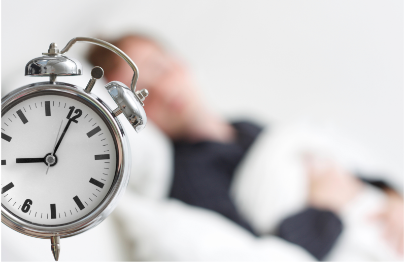 Man-slaapt-uit-klok-van-wekker-staat-op-8-uur