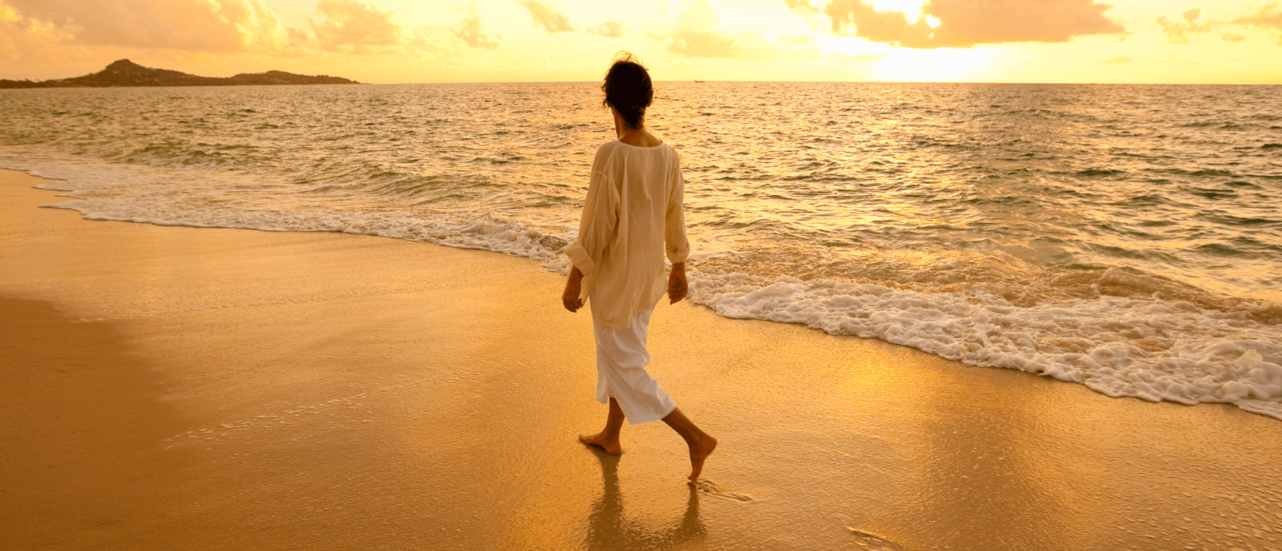 Vrouw wandelt alleen op het strand bij zonsondergang Vrouw wandelt alleen op het strand bij zonsondergang