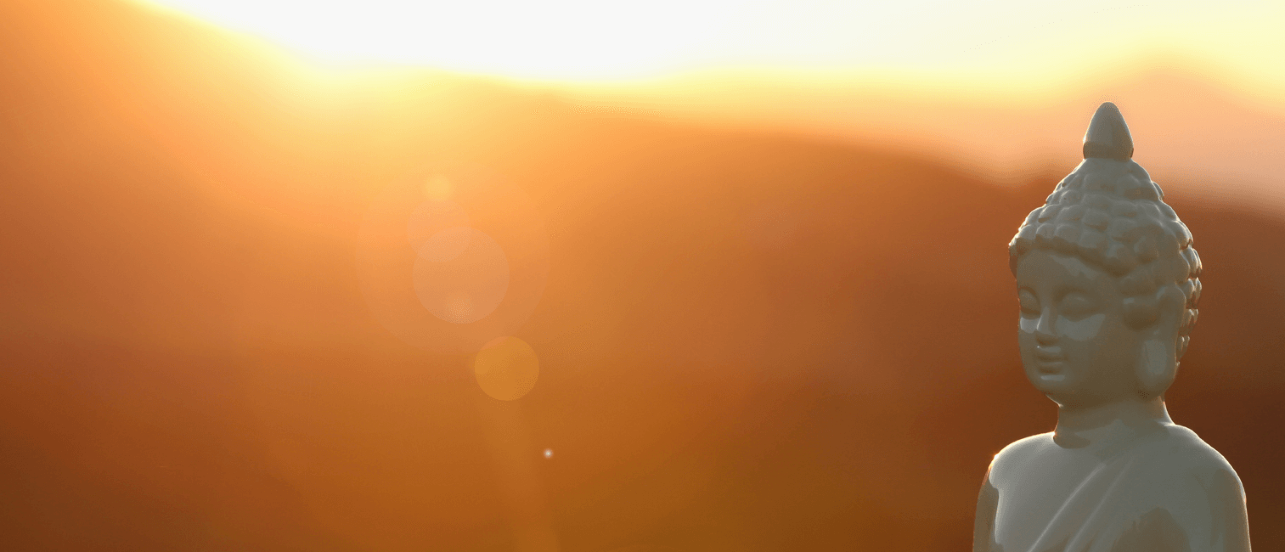 Wit boeddhabeeld tegen warme zonsondergang Wit boeddhabeeld tegen warme zonsondergang