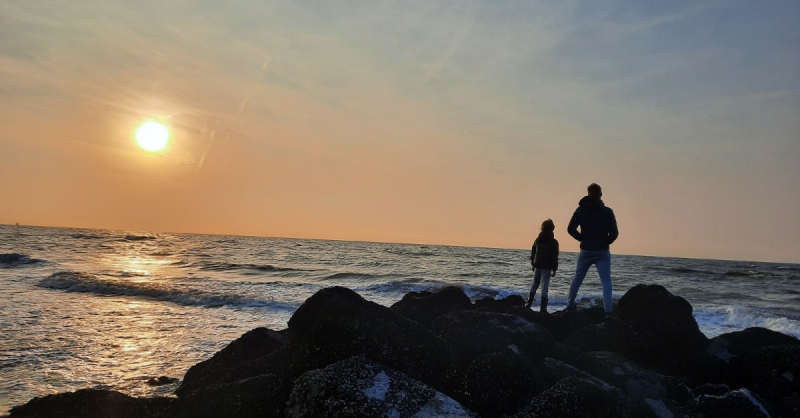 Mijn zoontje en partner op de golfbrekers tijdens een zomerse dag aan zee – symbool van rust, verbinding en houvast