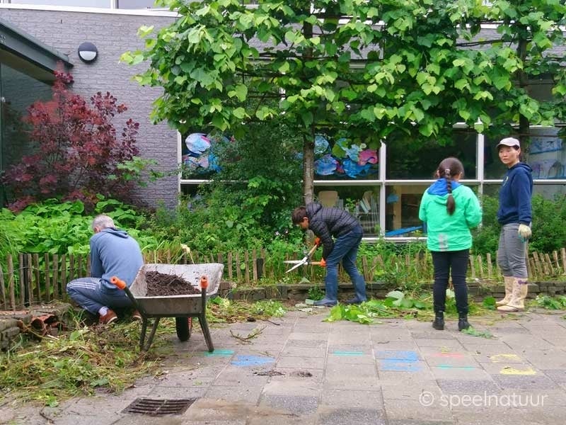 ouders werken samen op het groene schoolplein