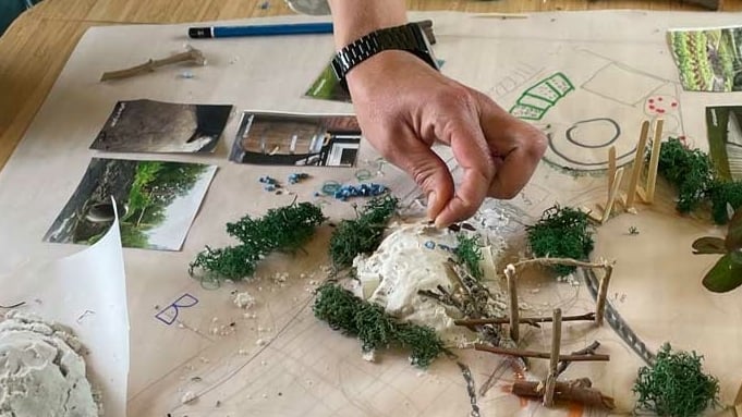 iemand maakt een maquette van een groen schoolplein