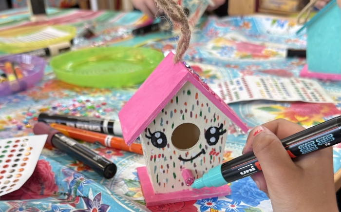 kinderen versieren mini vogelhuisjes met acrylstiften