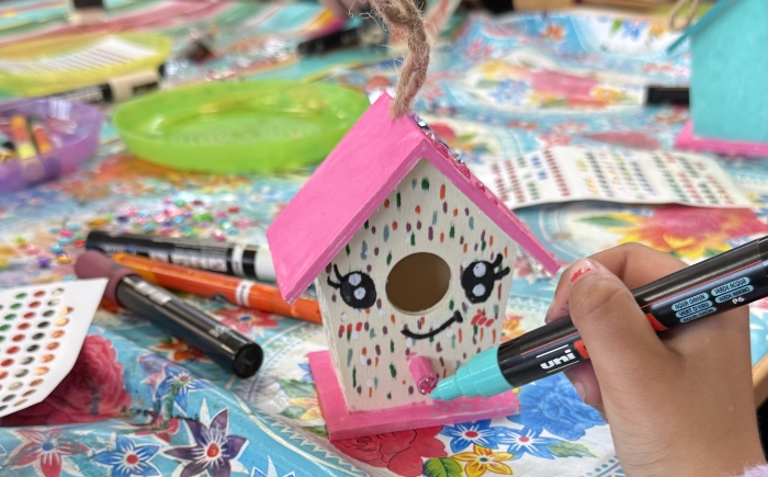 kinderen versieren mini vogelhuisjes met acrylstiften
