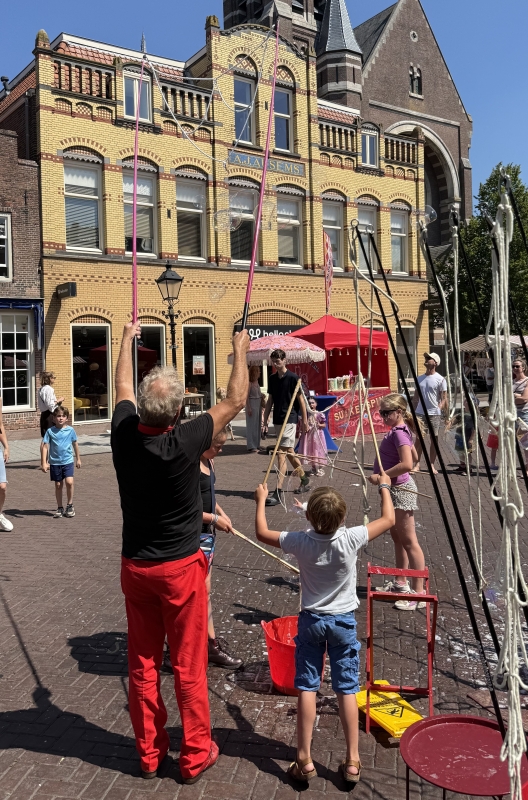 Mega zeepbellen artiest in rood pak Mega bellenblaas act op je evenement | Zo werkt het | Studio Angelart