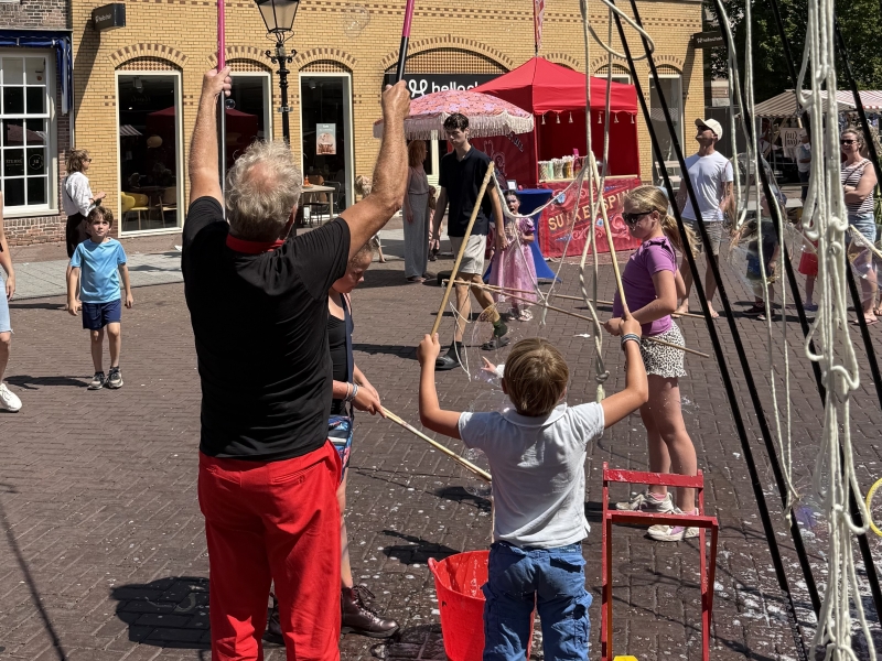 Bellenblaas artiest in rood pak