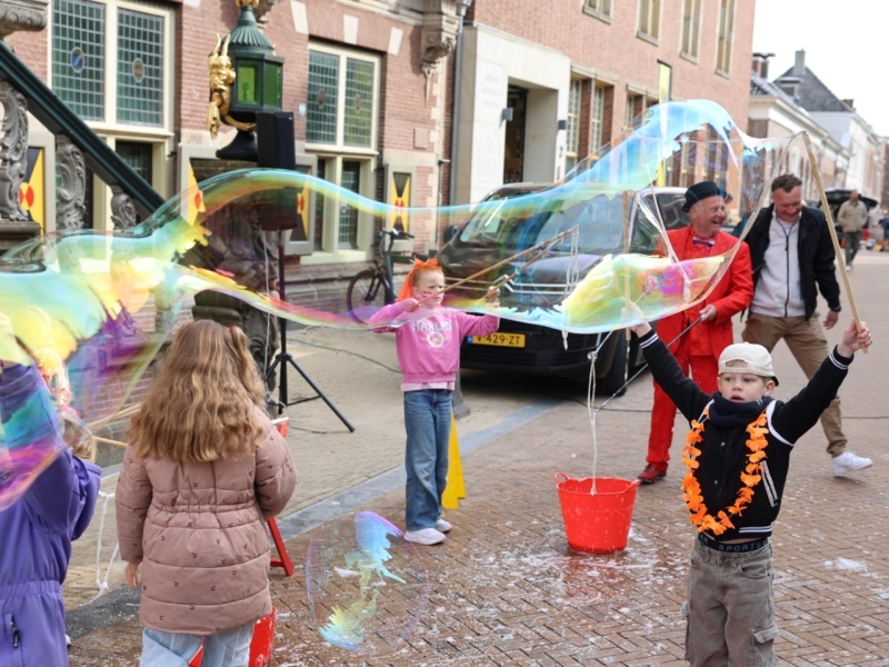 kinderen maken zeepbellen  op het plein tijdens Koningsdag in Bolsward