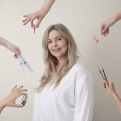 Een pose voor de foto met er omheen handen met een gellak, kleuren staaltjes een vijl en nailart penselen