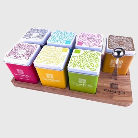 Losse thee in gekleurde theeblikjes op houten plank