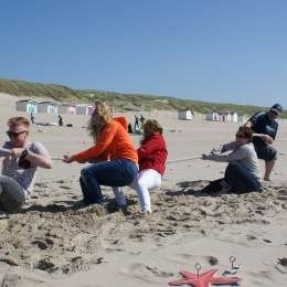 Groep deelnemers tijdens een actieve strandactiviteit op Texel, ideaal voor een bedrijfsuitje of groepsuitje
