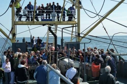 Grote groep mensen op een boot tijdens een excursie op de Waddenzee bij Texel