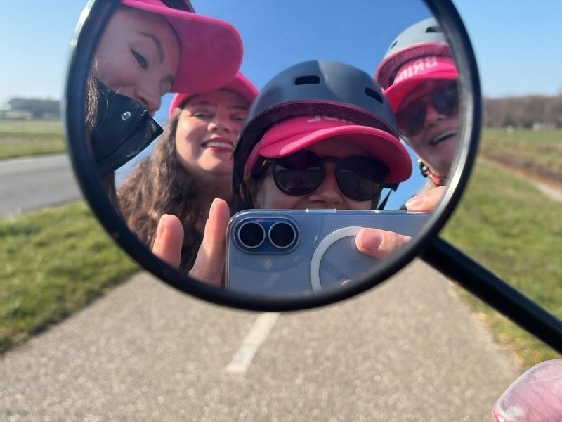 Groep deelnemers maakt selfie in spiegel tijdens solex groepsuitje op Texel