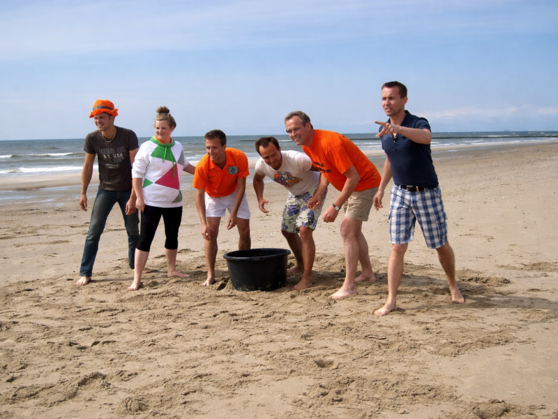 Strandactiviteiten tijdens een teamuitje op Texel groep die een strandspel speelt tijdens een afdelingsuitje op Texel