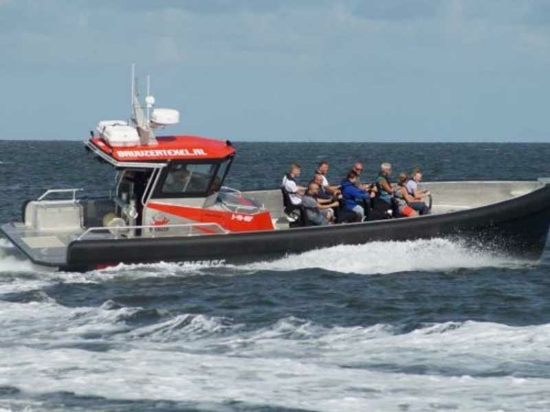 Groep mensen in een powerboat tijdens een stoer groepsuitje op Texel