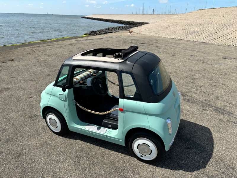 Elektrische Fiat Topolino op Texel met open cabriodak en deuren voor een ultiem eilandgevoel