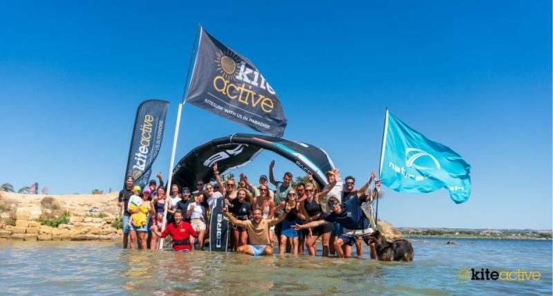 Group of kiters celebrating at Lo Stagnone Sicily with KiteActive flags