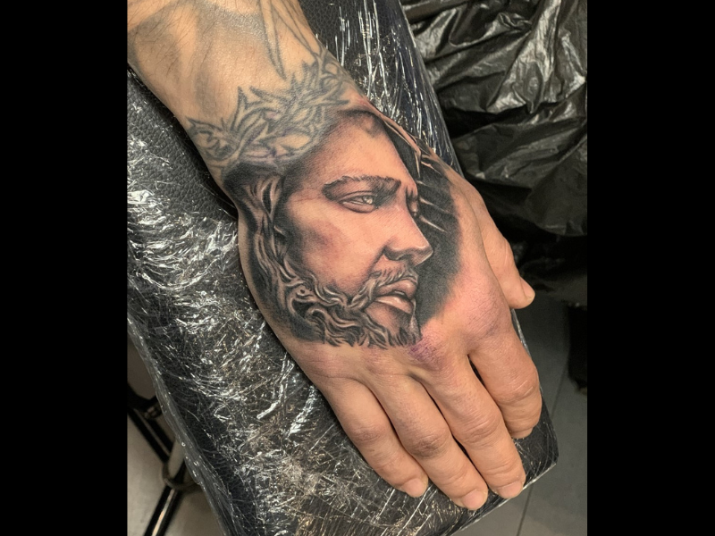 jezus tattoo op hand realisme