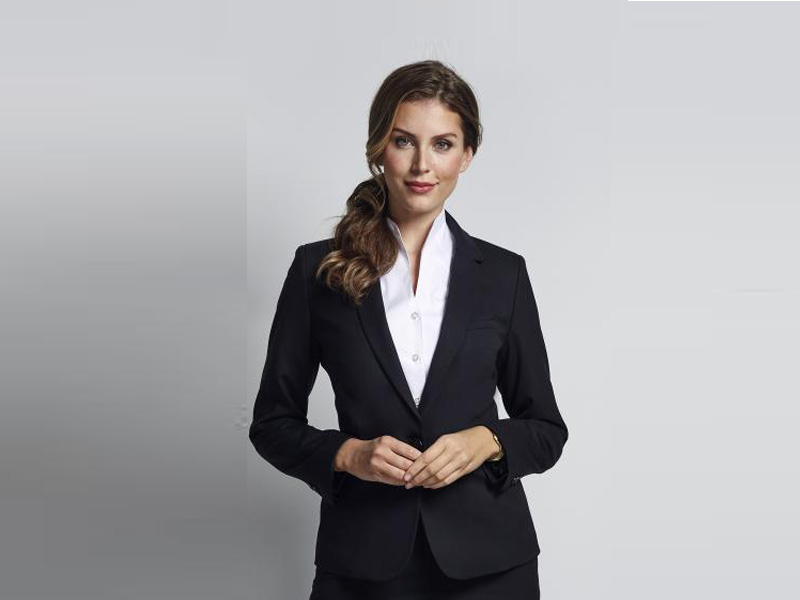 Dame gekleed in zwarte blazer, pantalon en witte blouse ideaal voor beveiliging en receptiediensten