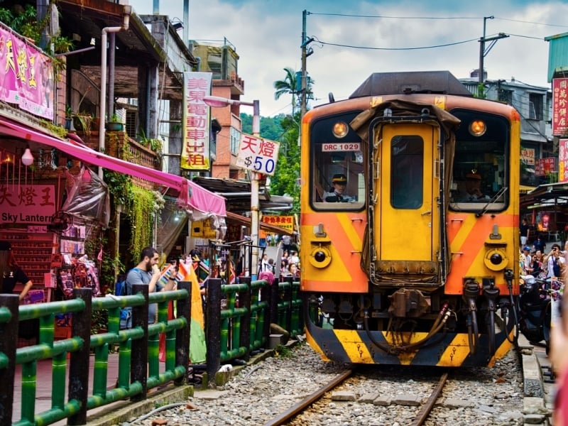 Trein dwars door het dorpje Shifen in Taiwan. Ontdek de unieke ervaring zelf tijdens jouw rondreis.