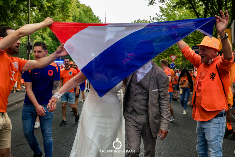 EK 2024 bruidspaar after weddingshoot voor de oranje bus bij de fanwalk van Onsoranje vlag