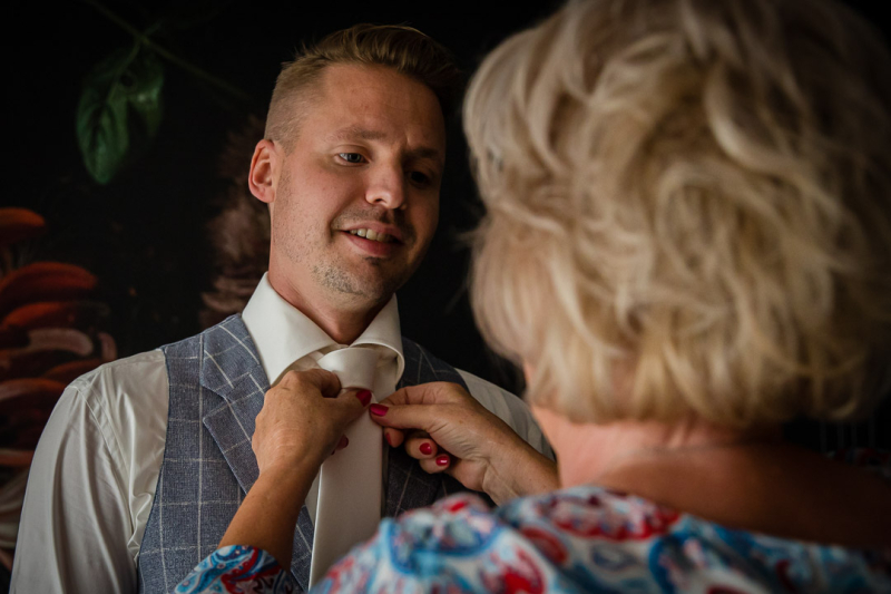 Moeder van de bruidegom helpt met stropdas in Schiedam