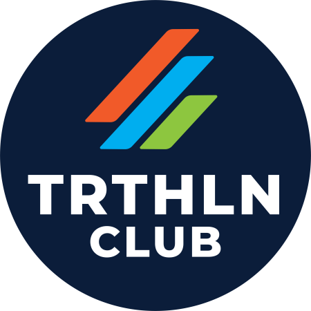 Rond logo van de TRTHLN Club met drie diagonale strepen in oranje, blauw en groen boven de witte tekst TRTHLN CLUB op een donkerblauwe achtergrond.