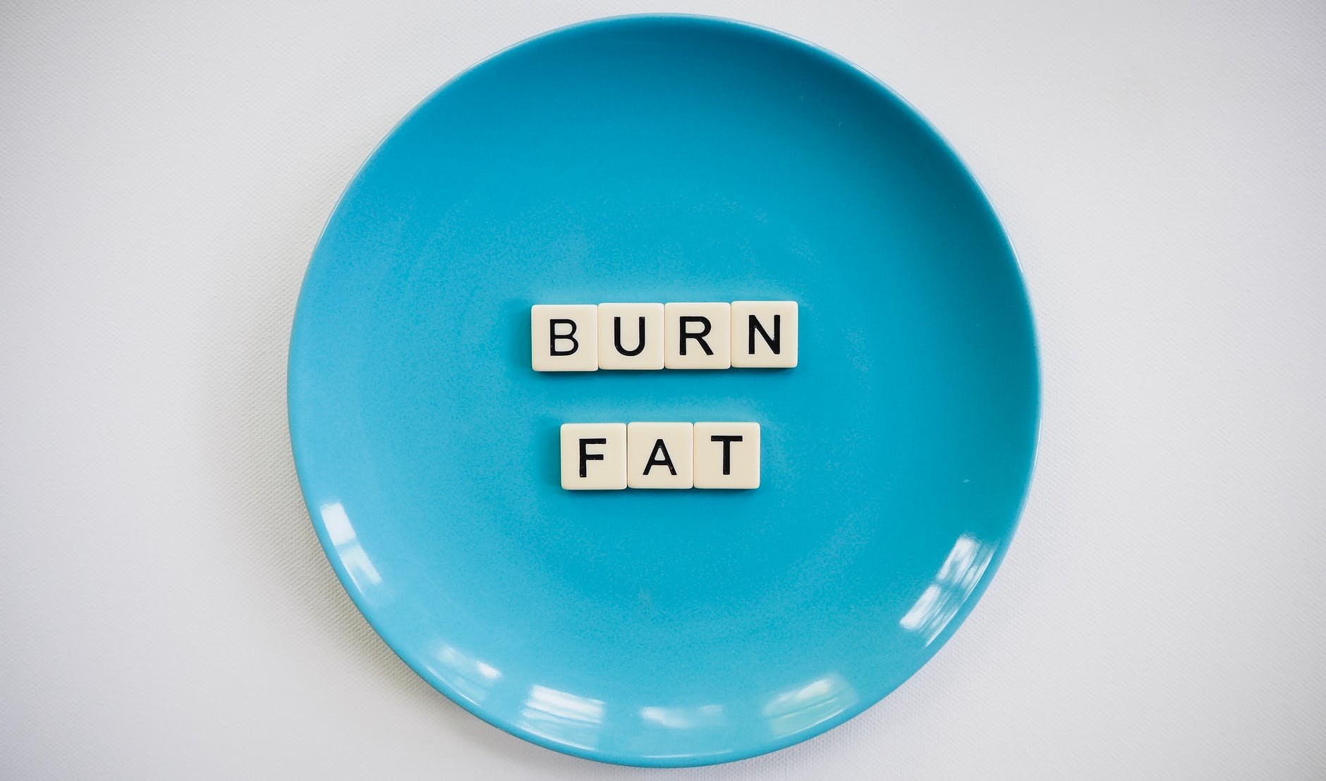 photo of a burn fat text on round blue plate. vet verbranden. bord.