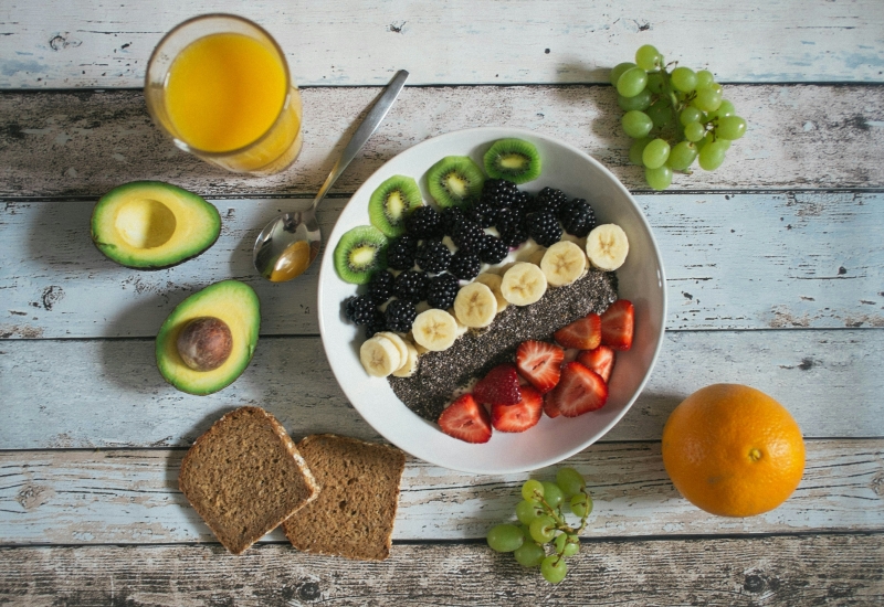 Bord met gezonde voeding, zoals fruit en groenten, om het belang van fysieke gezondheid in herstel te benadrukken